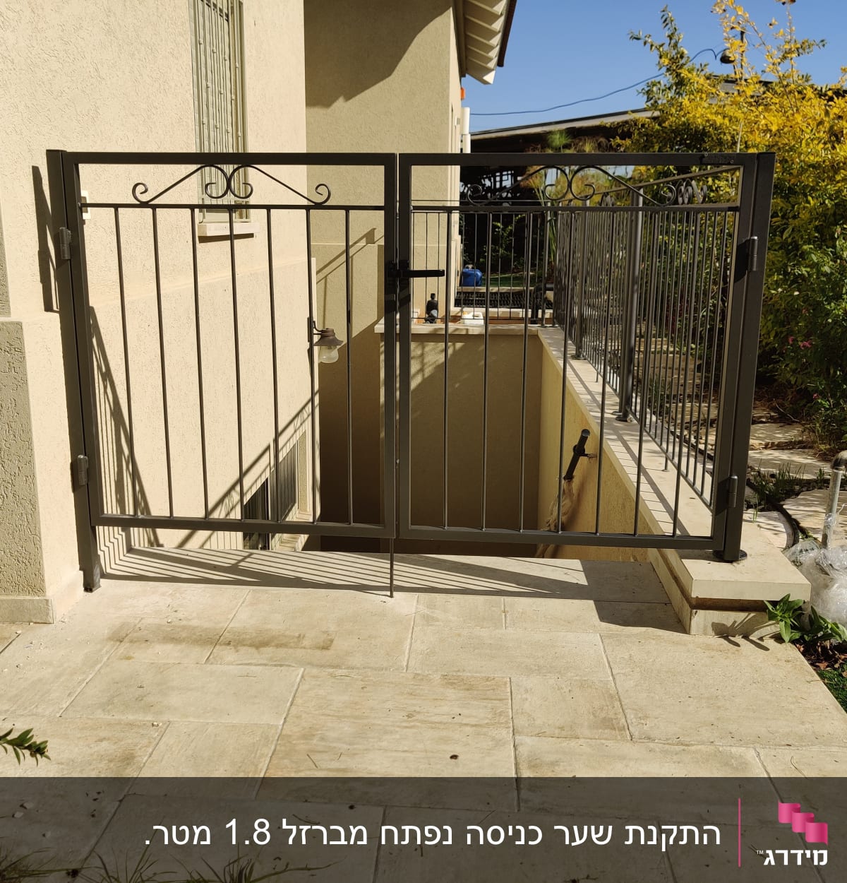 שער מתכת עם עיטורים על שביל מרוצף